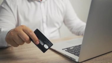 Alışveriş online kavram. adam elleri kredi kartı tutan ve dizüstü bilgisayar kullanarak. erkek el masada kartı çalar