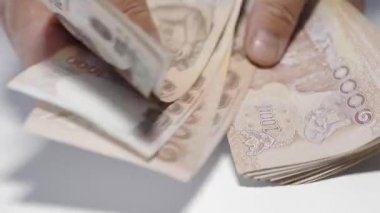 Thousansds Tay baht para sayma ellerini kapatın. Yakın Insan sayma Tay banknot, richman sayısı ve yüz tutan kadar. Masada Baht faturaları.