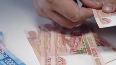 adam para veriyor, Rus Rublesi banknotları, masasının üzerinde rüşvet ve yolsuzluk konsepti.rus rublesi banknotları. Finansal tema. bir adam elinde banknot yığını.