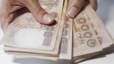 Thousansds Tay baht para sayma ellerini kapatın. Yakın Insan sayma Tay banknot, richman sayısı ve yüz tutan kadar. Masada Baht faturaları.