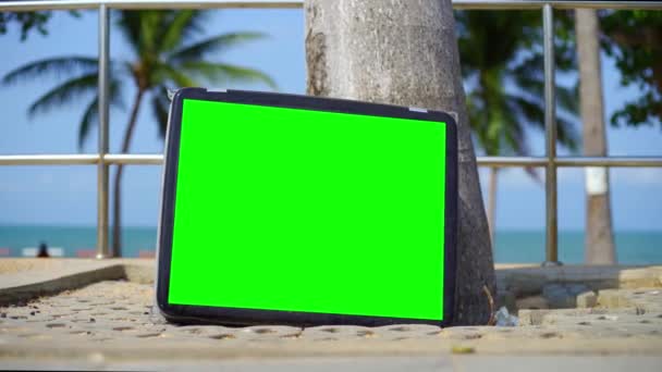 Телевізор стоїть на пляжі. Телевізор з зеленим екраном. Ви можете замінити зелений екран на кадри або зображення, які ви хочете — стокове відео