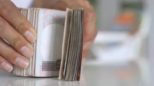 Närbild händer räkna av thousansds thailändska baht pengar. Närbild mänsklig räkning thailändsk sedel, Richman räkna och hålla hundra. Baht räkningar på bordet. — Stockfoto