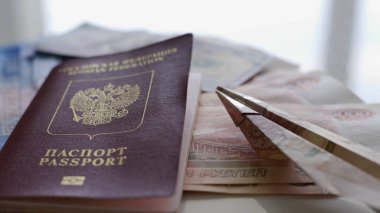 Beyaz bir masada çok para, pasaport ve paradan yapılmış küçük bir uçak var. Dinlenme kavramı, tatile hazırlık, seyahat.