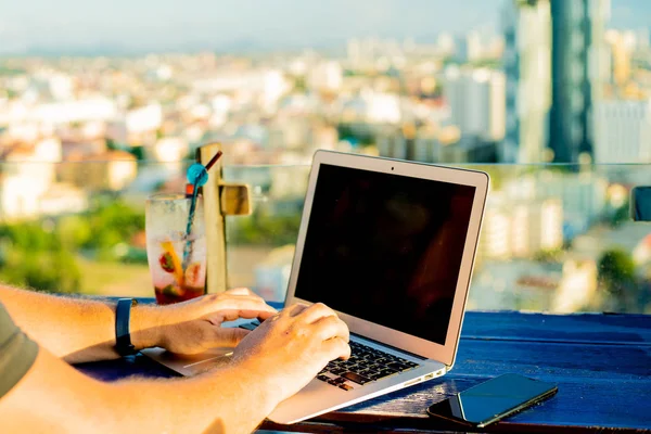 Чоловічий набір на ноутбук у кафе на даху висотного зросту з красивим панорамним видом на місто, крупним планом — стокове фото