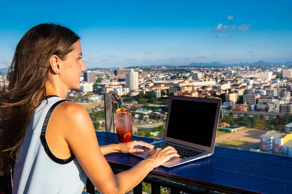 Lavori femminili su un computer portatile in un caffè sul tetto di un grattacielo con una bella vista panoramica della città, da vicino — Foto Stock