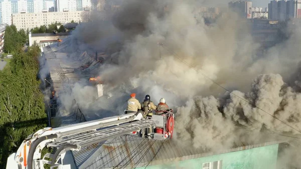 Nizhnevartovsk, Russia - 1 luglio 2019: i vigili del fuoco spengono un incendio sul tetto di un grattacielo residenziale. vista dall'alto — Foto Stock