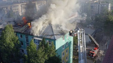 Nizhnevartovsk, Rusya - 1 Temmuz 2019: İtfaiyeciler bir konut yüksek binanın çatısında bir yangın söndürmek. üst görünüm