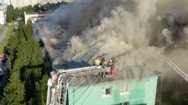 Nizhnevartovsk, Rusya - 1 Temmuz 2019: İtfaiyeciler bir konut yüksek binanın çatısında bir yangın söndürmek. üst görünüm