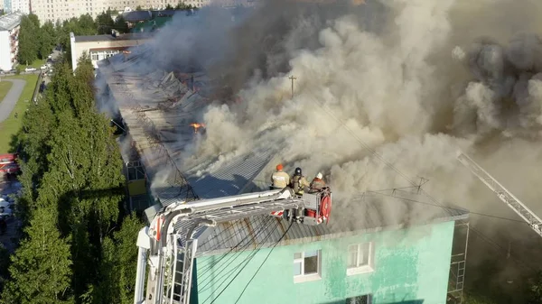 Nizhnevartovsk, Russia - 1 luglio 2019: i vigili del fuoco spengono un incendio sul tetto di un grattacielo residenziale. vista dall'alto — Foto Stock