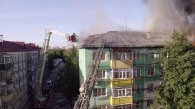 Nizhnevartovsk, Rusya - 1 Temmuz 2019: İtfaiyeciler bir konut yüksek binanın çatısında bir yangın söndürmek. üst görünüm