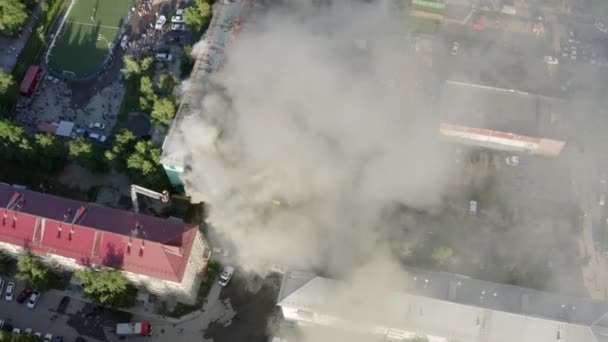 Nizhnevartovsk, Russland - 1. Juli 2019: Feuerwehrleute löschen einen Brand auf dem Dach eines Wohnhochhauses. Ansicht von oben — Stockvideo