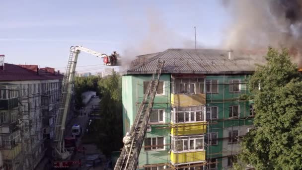 Нижневартовск, Россия - 1 июля 2019 года: пожарные тушат пожар на крыше жилого высотного здания. вид сверху — стоковое видео