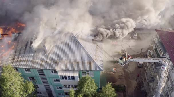 Nizhnevartovsk, Rusland-1 juli 2019: Brandweerlieden blussen een brand op het dak van een residentiële Highrise gebouw. Top View — Stockvideo