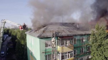 Nizhnevartovsk, Rusya - 1 Temmuz 2019: İtfaiyeciler bir konut yüksek binanın çatısında bir yangın söndürmek. üst görünüm