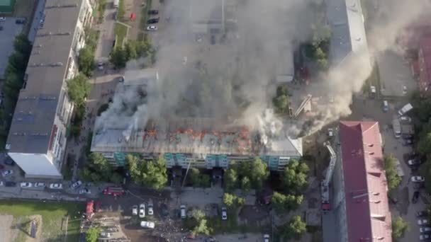 Nizhnevartovsk, Russland - 1. Juli 2019: Feuerwehrleute löschen einen Brand auf dem Dach eines Wohnhochhauses. Ansicht von oben — Stockvideo