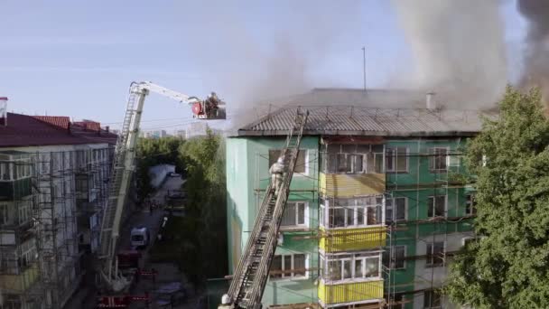 Nizhnevartovsk, Russia - 1 luglio 2019: i vigili del fuoco spengono un incendio sul tetto di un grattacielo residenziale. vista dall'alto — Video Stock