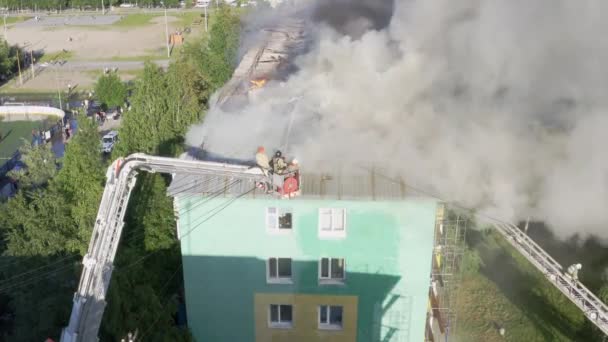 Nizhnevartovsk, Russia - 1 luglio 2019: i vigili del fuoco spengono un incendio sul tetto di un grattacielo residenziale. vista dall'alto — Video Stock