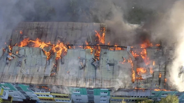 Burning roof of a residential high-rise building, clouds of smoke from the fire. top view