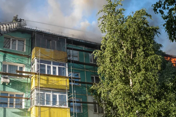 Tetto in fiamme di un grattacielo residenziale, nuvole di fumo dal fuoco. vista dall'alto — Foto Stock