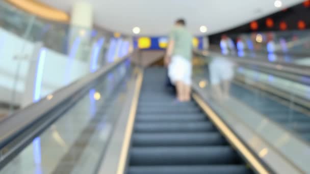 Rolltreppe im Einkaufszentrum in Großaufnahme. Im Hintergrund sind die Menschen beim Einkaufen aus dem Fokus. 4k. — Stockvideo