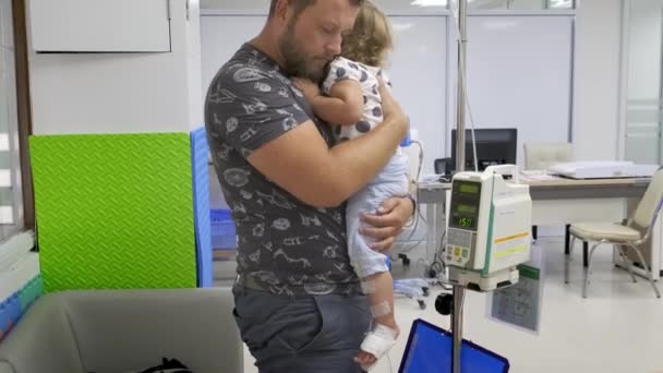 Pattaya, Thailand - May 12, 2019: Surviving sad Dad and crying little daughter in hospital. A little girl is injected. Medical intravenous drip drips, slow motion, 4k. — Stock Video