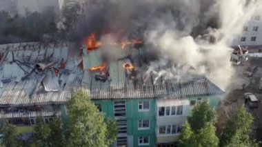 Yüksek katlı bir binanın yanan çatısı, yangından duman bulutları. üst görünüm
