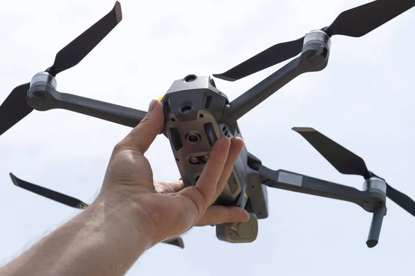 Mujer mano lanza dron para el vuelo, con el que se puede tomar fotos y filmación de vídeo, primer plano — Foto de Stock