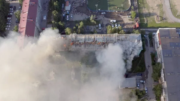 Burning roof of a residential high-rise building, clouds of smoke from the fire. top view