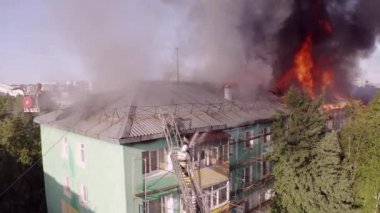 Yüksek katlı bir binanın yanan çatısı, yangından duman bulutları. üst görünüm