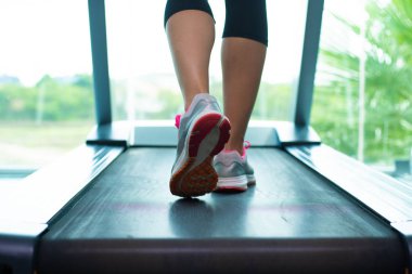 Spor salonunda a. Koşu bandı üzerinde pembe spor ayakkabı lı kadın bacaklarını kapatın