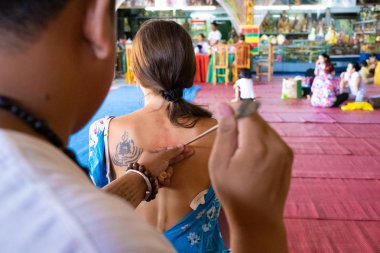 yantra dövme veya sak yant, Tay kutsal dövme. usta özel bir yağ ile bir kız renksiz dövme Sak Yant çizer. Tayland. seçici odaklama