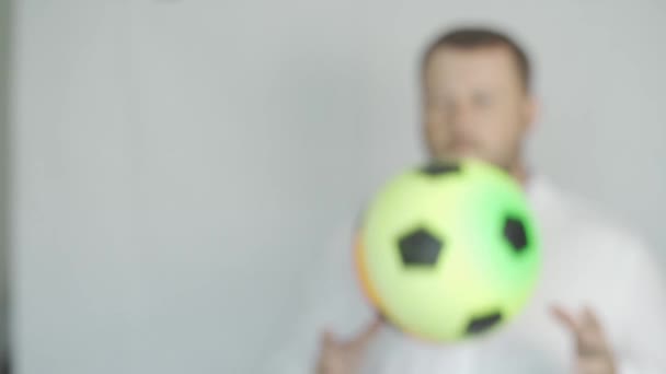 Samec s plnovousem hází míč na bílé pozadí, koncept úspěchu, pomalý pohyb, měkké zaostření — Stock video