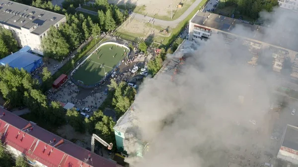 Burning roof of a residential high-rise building, clouds of smoke from the fire. top view