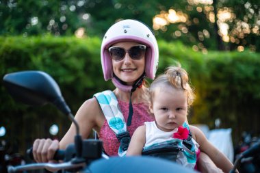 güzel anne ve kızı motosiklet veya scooter ile gitmek için hazırlanıyor.