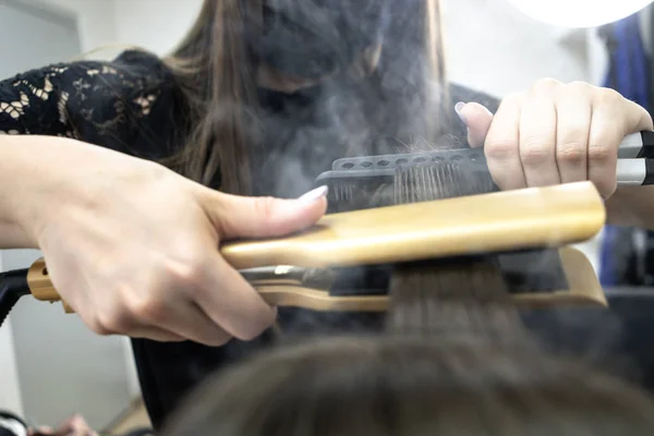 Söt tjej med lång brunett hårfrisör gör hårlaminering i en skönhetssalong. begreppet hårvårds behandling, ånga från håret — Stockfoto