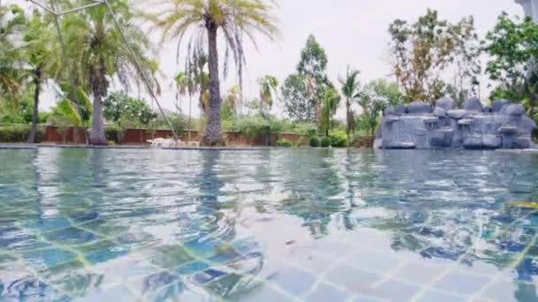 Piscine bleue avec feuilles d'automne avec une cascade .
