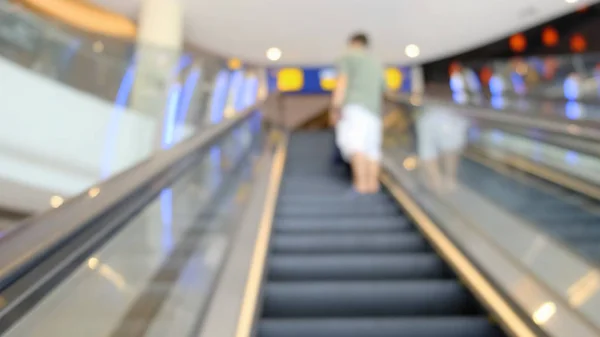 Escalator in the mall close-up. In the background, people are out of focus for shopping. 4K.