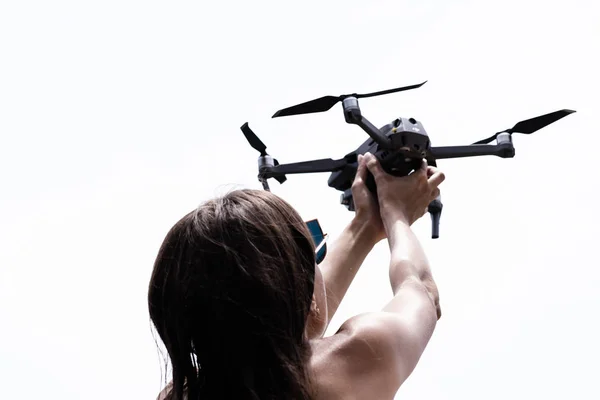 Femme main lance drone pour le vol, avec lequel vous pouvez prendre des photos et le tournage vidéo, gros plan — Photo