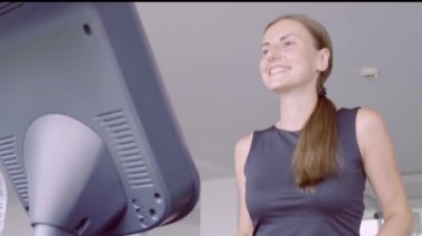 spor salonunda koşu bandı üzerinde çalışan mutlu gülümseyen kadın fitness merkezinde.