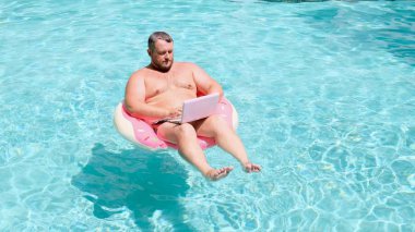 havuzda suda şişme yüzük olan erkek. Yüzme Circle komik şişman adam.