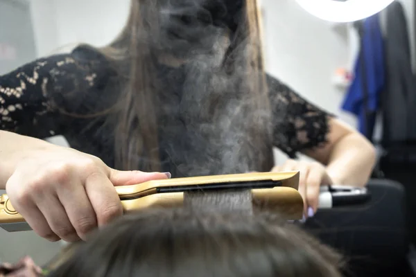 Söt tjej med lång brunett hårfrisör gör hårlaminering i en skönhetssalong. begreppet hårvårds behandling, ånga från håret — Stockfoto