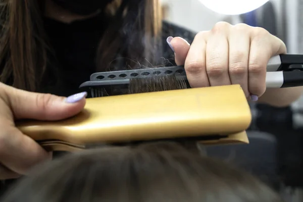 Милая девушка с длинными брюнетками парикмахер делает ламинирование волос в салоне красоты. концепция ухода за волосами, пар из волос — стоковое фото