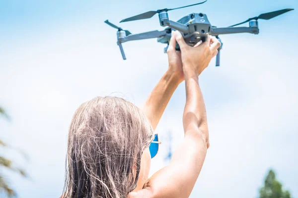 Femmina lancia a mano drone per il volo, con il quale è possibile scattare foto e riprese video, primo piano — Foto Stock