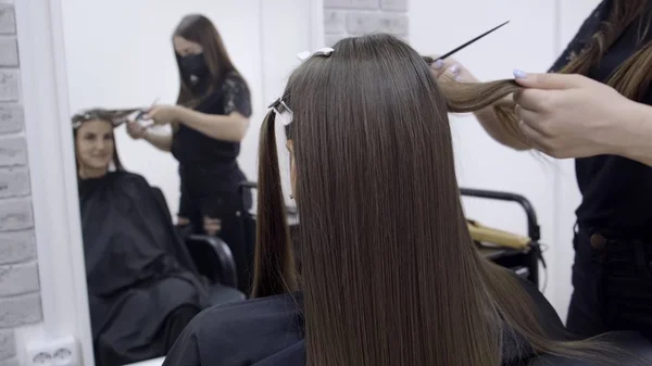 미용사는 갈색 머리를 가진 소녀를위한 뷰티 살롱에서 머리 라미네이션을합니다. 헤어 케어 컨셉. — 스톡 사진