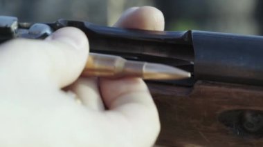 Erkek avcı avlanmaya hazır. Adam ava, spor. Avcı adam. Avlanma dönemi. Silahlı, tüfekli bir erkek. Adam av tüfeğini şarj ediyor.