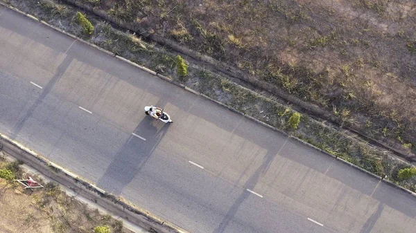 Paar fährt Motorrad auf Landstraße. Aktien. Draufsicht auf den fahrenden Motorradfahrer und seine Frau. Romantische Reise. im Sommer auf dem Motorrad. — Stockfoto