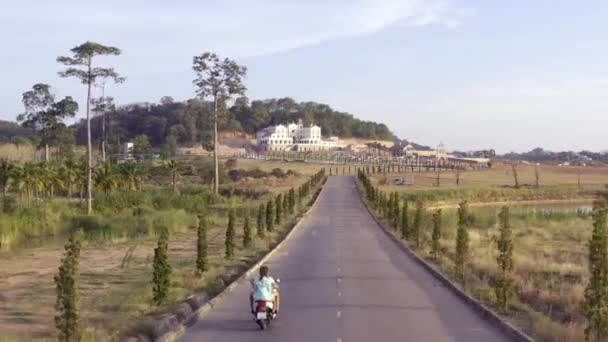 パタヤ、タイ - 2019年5月18日:田舎道でオートバイに乗るカップル。株式。乗馬モーターサイクリストと彼の女性のトップビュー。ロマンチックな旅夏のオートバイで. — ストック動画