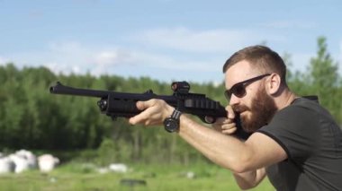 erkek bir ateşli silah ile vuruyor, av tüfeği açık havada.