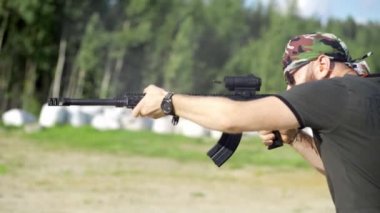 erkek bir ateşli silah ile vuruyor, av tüfeği açık havada.