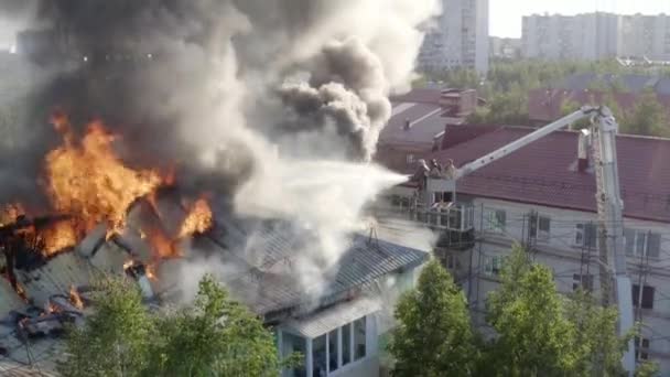 Пожарные тушат пожар на крыше жилого высотного здания. вид сверху — стоковое видео
